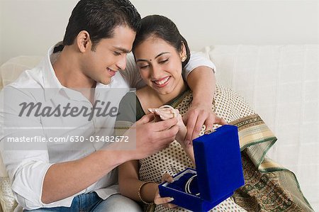 Man putting bangles on a woman's hand