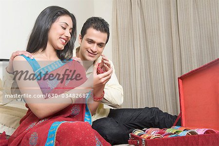 Femme mettant sur bracelets avec son mari assis à côté d'elle