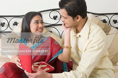 Man giving a necklace to a woman