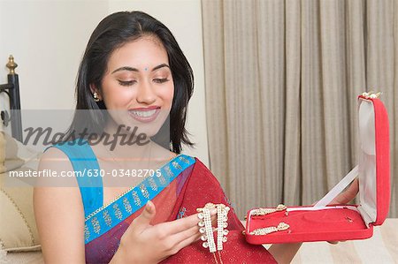 Woman holding a necklace and smiling