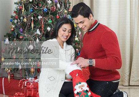 Couple holding a Christmas stocking and smiling