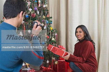 Homme filmer sa femme avec Noël présente