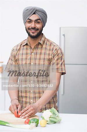 Porträt eines Mannes, der in der Küche Gemüse Hacken