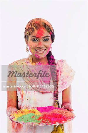 Frau hält einen Teller mit Pulver Farbe auf Holi