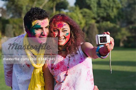 Couple de prendre une photo d'eux-mêmes avec une caméra sur Holi