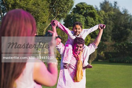 Woman filming her family with a video camera on Holi