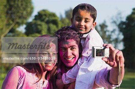 Photo de famille prise d'eux-mêmes avec un appareil photo numérique sur Holi