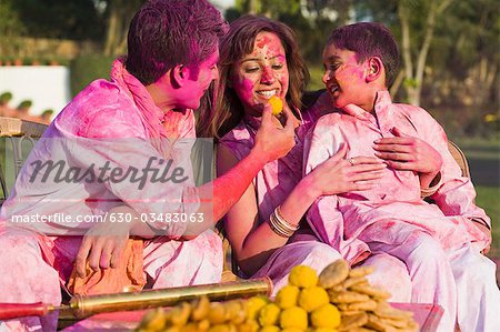 Famille fête Holi avec des cuisines indiennes traditionnelles