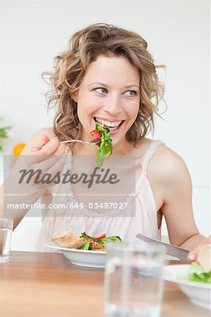 Femme manger salade mixte sur table