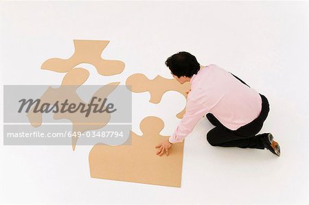 Business man looks to finish puzzle