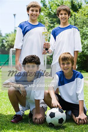 Junge Fußball-Teamkollegen posiert mit Trophäe, Porträt