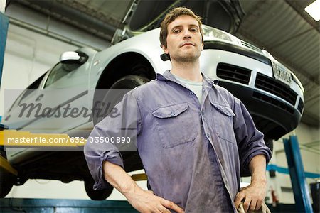 Mécanicien auto atelier de réparation, voiture sur ascenseur hydraulique en arrière-plan