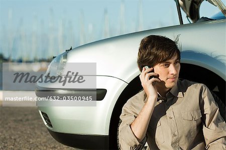 Man having car trouble, making phone call with cell phone