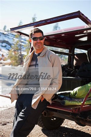 Portrait of Man Leaning against Tailgate of Car, Lake Tahoe, California, USA