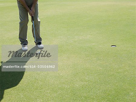 Man playing golf, on putting green