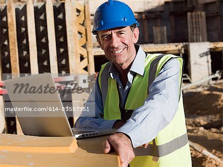 Homme d'âge mûr avec portable sur chantier