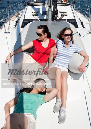 Drei Mädchen sitzen auf yacht