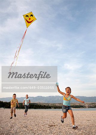 Children flying kite at beach
