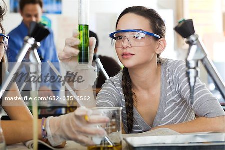 High school student conducting experiment in science class