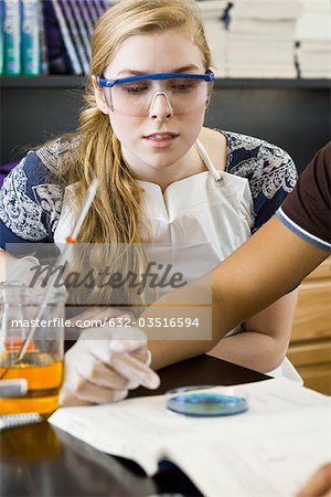 Élève du secondaire mène l'expérience en classe de chimie