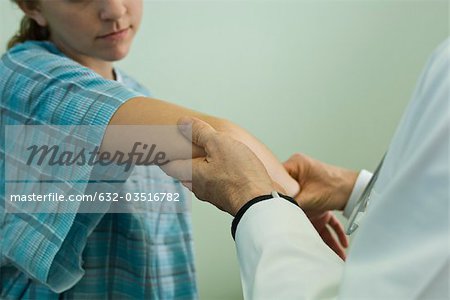 Doktor Arm des Patienten untersuchen