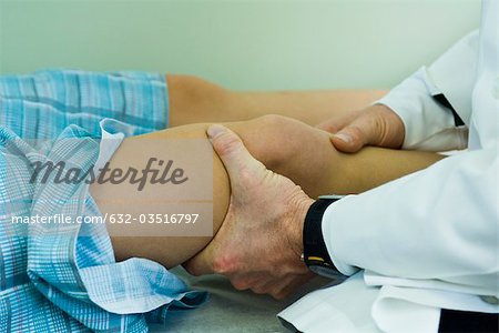 Doctor examining patient's leg and knee