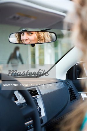 Femme au volant, reflet dans le rétroviseur