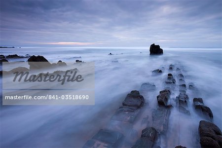 Waves rush over the rocky ledges at Sandymouth Bay in North Cornwall, England, United Kingdom, Europe