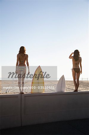 Backview des jeunes femmes avec des planches de surf, debout sur la plage, Zuma Beach, Californie, USA
