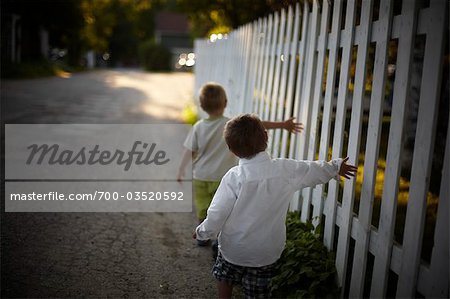 Boys Walking Beside White Picket Fence, Sauble Beach, Ontario, Canada