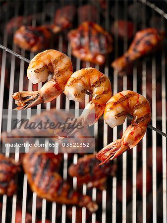 Grillé, brochettes de crevettes sur un gril au poulet