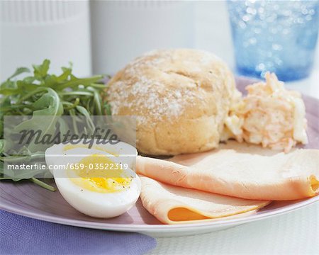 Ham with boiled egg, rocket and bread roll