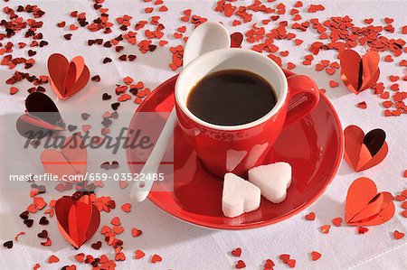 Une tasse d'espresso avec morceaux de sucre en forme de coeur