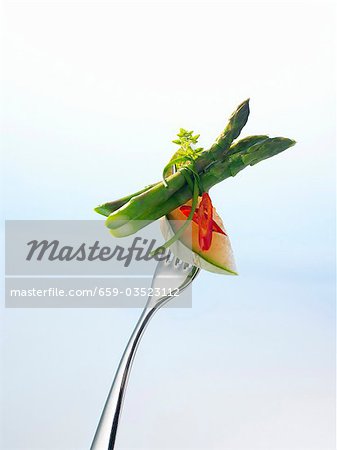 Charentais melon, chilli and green asparagus on a fork