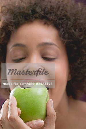 Young woman biting into an apple