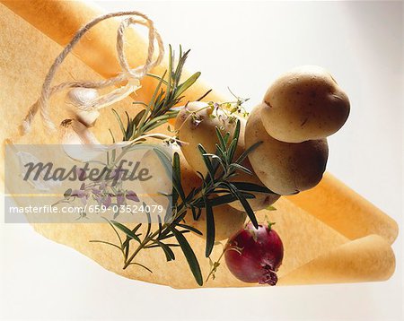 Potatoes with herbs, onion and garlic on baking parchment