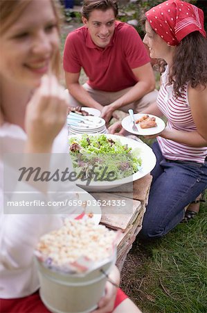 Young people with popcorn and salad at a barbecue