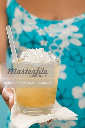 Woman holding cocktail in glass with the word 'Caipirinha' Woman holding cocktail in glass with the word 'Caipirinha'