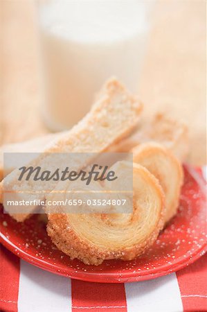 Pâtisseries sur plaque rouge en face de verre de lait Pâtisseries sur plaque rouge en face de verre de lait