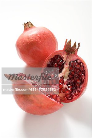 Two pomegranates, one whole and one halved