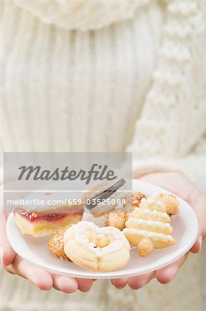 Frau hält verschiedene weihnachtsgebäck auf Platte