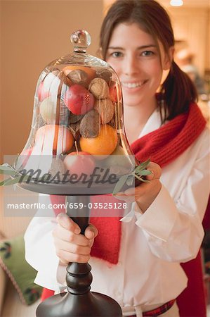 Femme tenant des fruits sous le couvercle en verre (décoration de table de Noël)