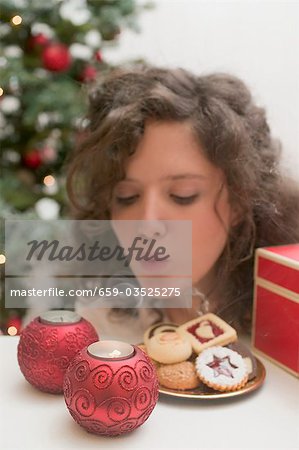 Woman blowing out tealights (Christmas)