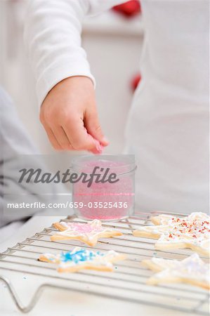 Enfant décorer des biscuits de Noël avec sucre