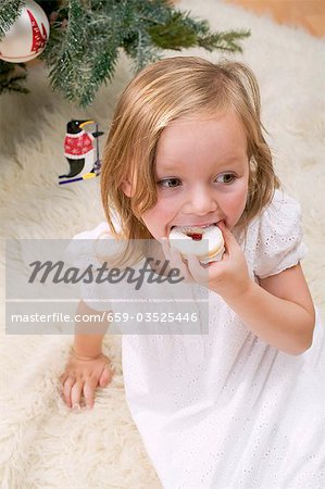 Small girl eating jam biscuit