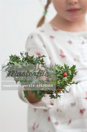 Small girl holding holly wreath