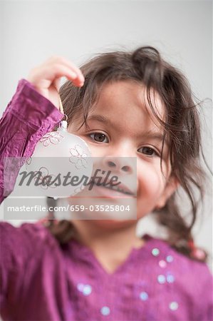 Small girl holding Christmas bauble