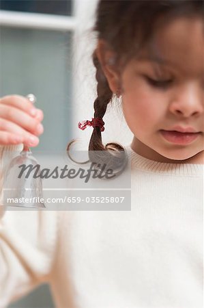 Small girl holding Christmas bell