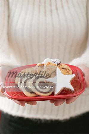 Woman holding plate of Christmas biscuits