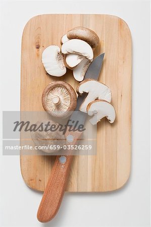 Shiitake mushrooms with knife on chopping board